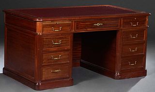 English Carved Cherry Georgian Style Desk, 20th c., the rounded edge and corner top with an inset gilt tooled leather writing surface over a center fr