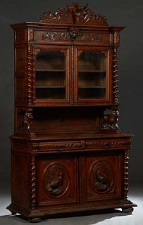 French Provincial Henri II Style Carved Oak Buffet a Deux Corps, c. 1880, with a large relief carved deer crest on a breakfront top over a setback lio