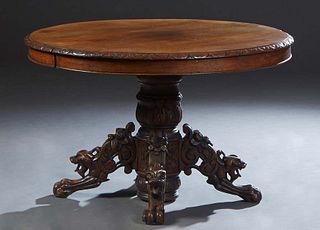 French Henri II Style Carved Oak Dining Table, c. 1880, the circular carved edge top opening to accept leaves, on a large central tapered urn support 