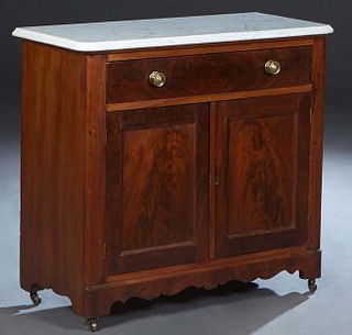 American Carved Walnut Marble Top Washstand, late 19th c., the later figured white ogee edge marble over a frieze drawer above double cupboard doors, 