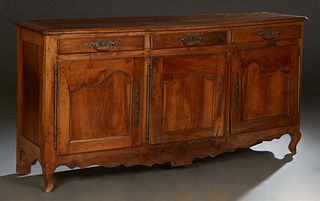 French Provincial Carved Walnut Louis XV Style Sideboard, 19th c., the stepped canted corner top over three frieze drawers with iron handles, over thr