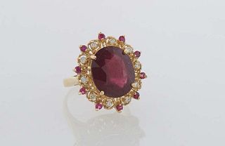 Lady's 14K Yellow Gold Dinner Ring, with a large oval ruby atop a pierced border with small round rubies separated by round ruby "points," H.- 7/8 in.