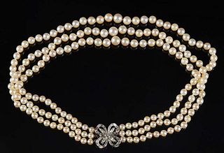 Three Strand 6mm Pearl Choker, with a 14K white gold floriform clasp, with a center .25 ct. round diamond, flanked by marquise and baguette diamonds, 