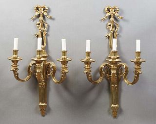 Pair of Louis XVI Style Gilt Bronze Three Light Wall Sconces, 20th c., with a bow and ribbon garland surmounted torch form back plate, issuing three s