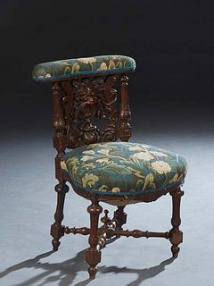 French Renaissance Style Carved Oak Cockfighting Chair, late 19th c., the padded armrest over a back with a pierce carved Northwind face flanked by tu