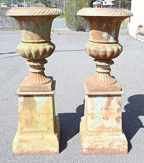 Pair of Iron Urns on Square Pedestals, height 55 inches, inside diameter 16 inches.