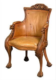Victorian Oak Armchair, having carved griffin crest; leather upholstery back and seat; and carved winged gargoyle hand rests raised on claw feet with 