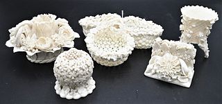 Five Belleek Encrusted Flower Pieces, to include a small box, triple bowl with handles, card holder, candlestick, along with a small vase; three havin