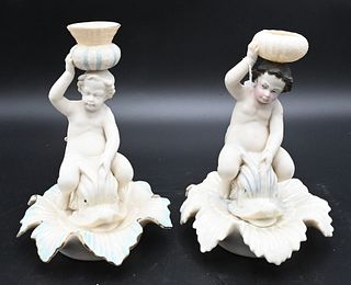 Eight Piece Belleek Group, to include two putti figural candlesticks on dolphin bases, height 7 inches; cornucopia vases; shell dishes, etc.; black an