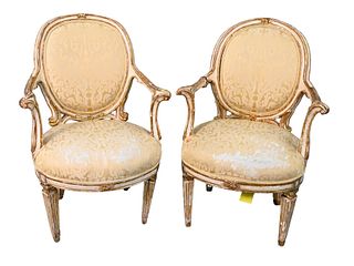 Pair of Early Italian Neoclassical Parcel Armchairs, gilt and white painted, height 38 inches, width 26 inches, (one arm broken near back). Provenance