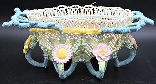 Belleek Porcelain Rathmore Basket, having colorful flowers and leaves, branch handles, footed base, brown mark on bottom, length 13 1/2 inches. Proven