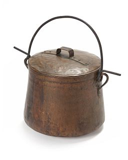 A large hammered copper and iron cooking pot