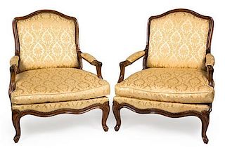 A Pair of Louis XV Style Carved Walnut Fauteuils Height 39 inches.