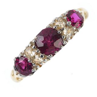 An Edwardian 18ct gold ruby three-stone and diamond ring. The graduated circular-shape ruby line, wi