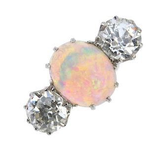 An opal and diamond three-stone ring. The oval opal cabochon, with circular-cut diamond sides, to th