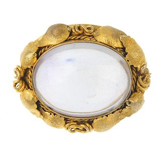 A late 19th century gold rock crystal brooch. The oval rock crystal cabochon, within a textured, scr