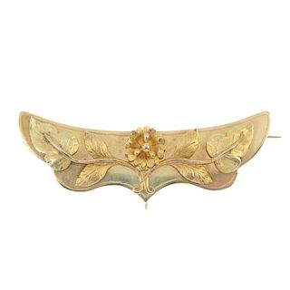A late 19th century gold brooch. The textured, bi-colour floral motif, raised to the scalloped mount