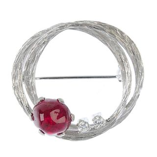 A 1970s ruby and diamond brooch. The textured wreath, with ruby cabochon and twin brilliant-cut diam