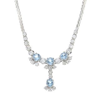 An aquamarine and diamond necklace. The front designed as a series of circular-shape aquamarines, wi