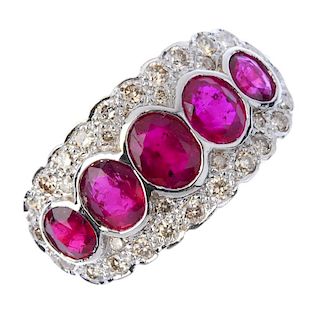 A ruby and diamond dress ring. The oval-shape ruby collet graduated line, within a brilliant-cut dia