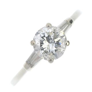 A diamond single-stone ring. The brilliant-cut diamond, to the tapered baguette-cut diamond shoulder