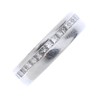 A platinum diamond band ring. The square-shape diamond line, within a channel setting to the plain b