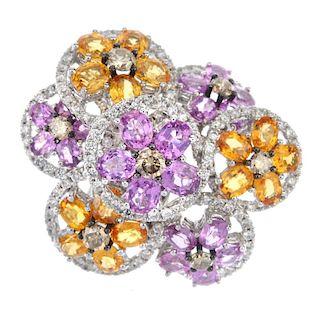 A diamond and sapphire ring. Designed as a series of oval-shape pinkish-purple sapphire, orange sapp