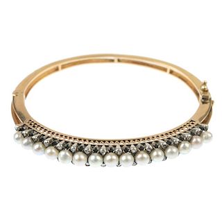 A cultured pearl and diamond hinged bangle. The cultured pearl line, with rose-cut diamond double sp