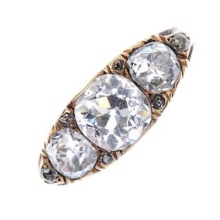 An early 20th century 18ct gold diamond three-stone ring. The graduated old-cut diamond line, with r