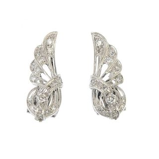 A pair of mid 20th century diamond ear clips. Each of openwork design, the stylised wing, set throug