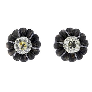 A pair of diamond ear studs. Each designed as an old-cut diamond, within a scalloped surround. Estim