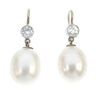 A pair of diamond and cultured pearl ear pendants. Each designed as a cultured pearl drop, suspended