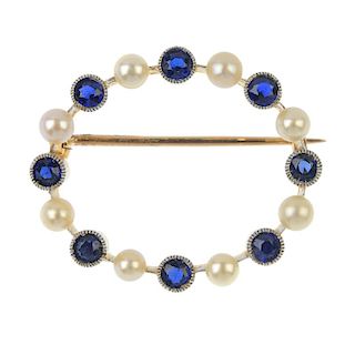 An early 20th century gold sapphire and seed pearl wreath brooch. Comprising an alternating circular
