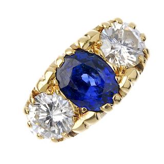 An 18ct gold sapphire and diamond three-stone ring. The oval-shape sapphire, between brilliant-cut d