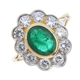 An emerald and diamond cluster ring. The oval-shape emerald collet, within a brilliant-cut diamond s
