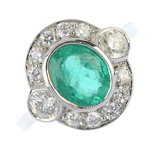 An emerald and diamond cluster ring. The oval-shape emerald collet, with brilliant-cut diamond colle