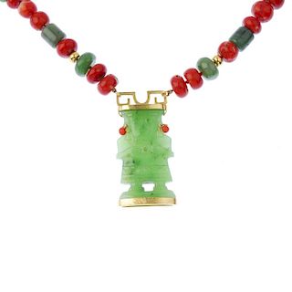 A nephrite jade and coral necklace. The carved nephrite idol with coral bead earrings, suspended fro