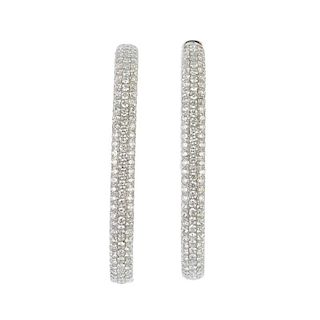 A pair of diamond ear hoops. Each designed as a pave-set brilliant-cut diamond hinged hoop. Total di