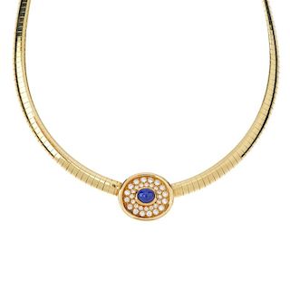 A sapphire and diamond collar. The oval sapphire cabochon, within a brilliant-cut diamond double sur