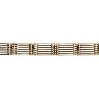 An early 20th century 15ct gold gate bracelet. Designed as a series of seven bar gate links, to the