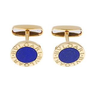 BULGARI - a pair of lapis lazuli cufflinks. Each designed as a lapis lazuli disc, within a Bulgari l