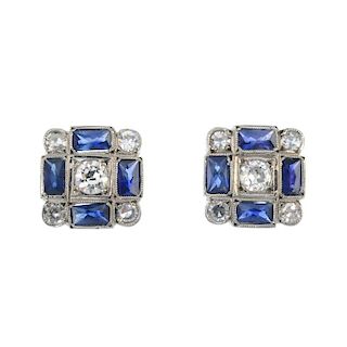 A pair of diamond and sapphire ear studs. Each designed as an old-cut diamond, within a rectangular-