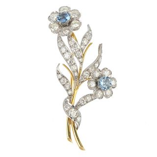 An aquamarine and diamond floral spray brooch. The circular-shape aquamarine and brilliant-cut diamo