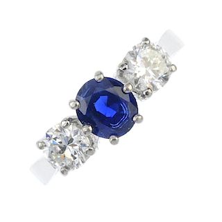 A sapphire and diamond three-stone ring. The oval-shape sapphire, to the brilliant-cut diamond sides
