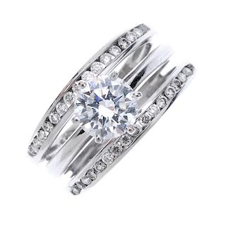 A diamond dress ring. Of triple band design, the brilliant-cut diamond to the similarly-cut diamond