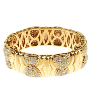 A diamond hinged bangle. Comprising a series of pave-set diamond overlapping panels, with grooved sp