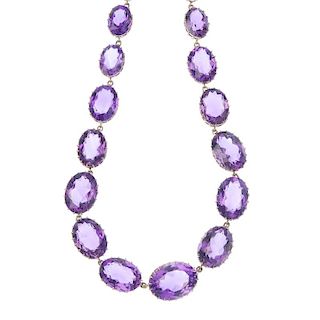 An amethyst riviere. Designed as a series of graduated oval-shape amethysts, to the push-piece clasp