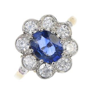 A sapphire and diamond cluster ring. The oval-shape sapphire, within a brilliant-cut diamond surroun