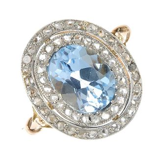 An early 20th century platinum and 18ct gold topaz and diamond cluster ring. The replacement oval-sh