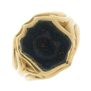 A late 19th century 18ct gold bloodstone signet ring. The shield-shape bloodstone, with grooved and